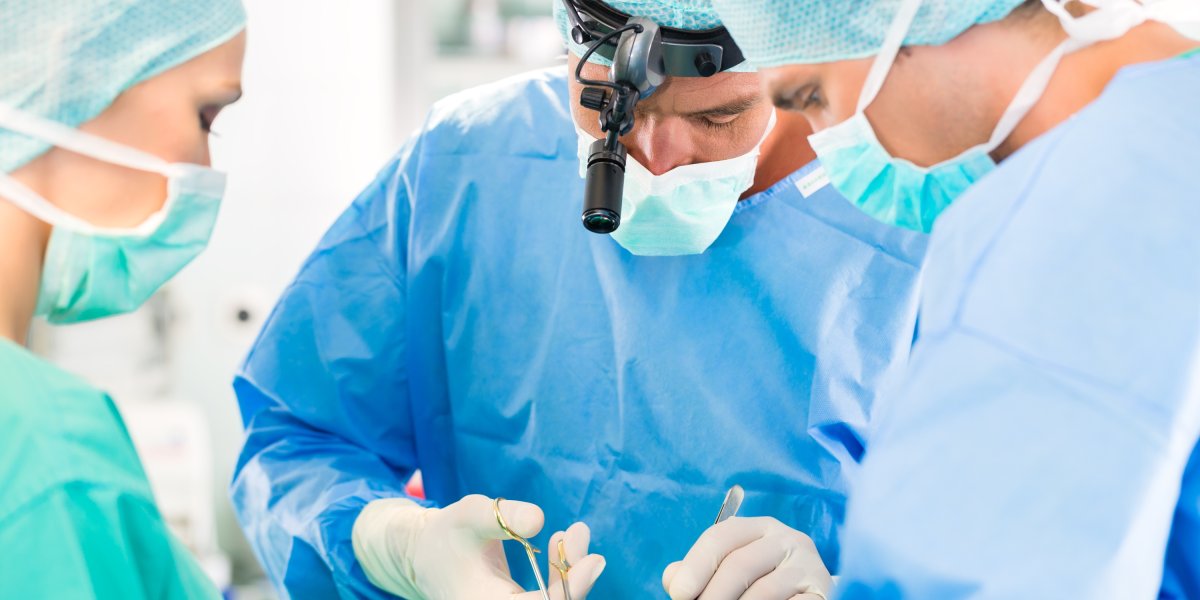 Surgeons wearing surgical loupes operating with full concentration in the operating theatre.