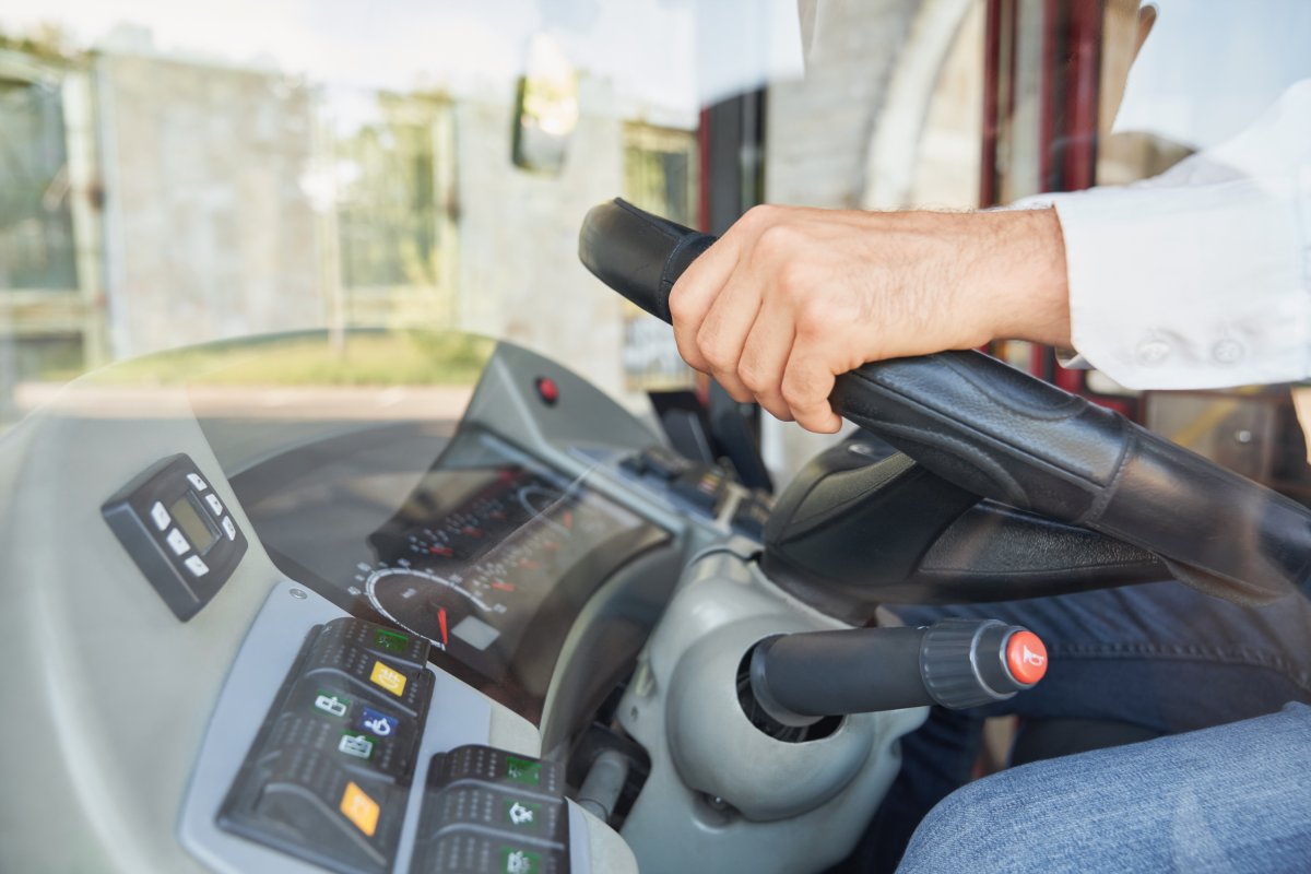 Hand on the steering wheel of a coach.