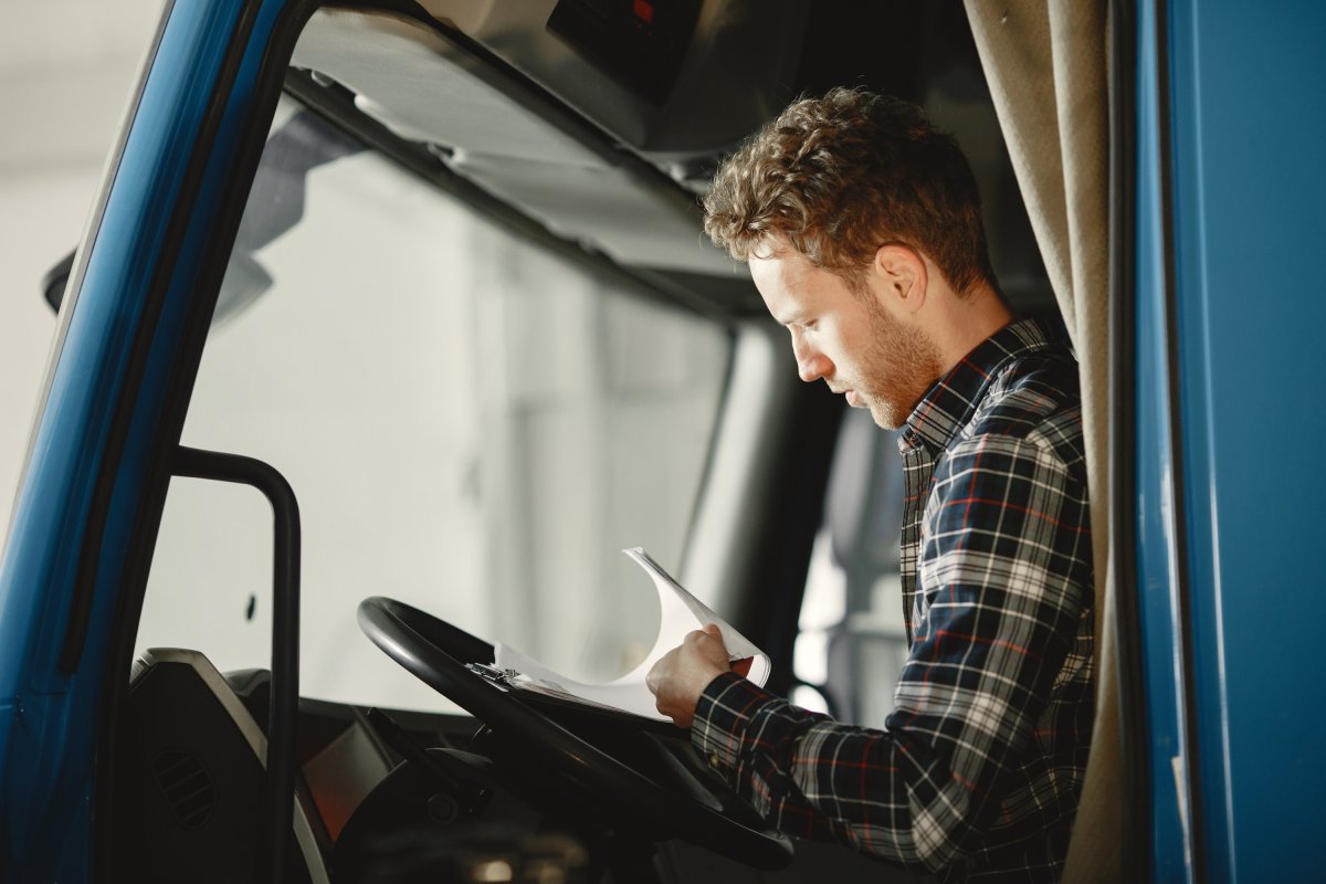 Truck driver checking paperwork in the cab.
