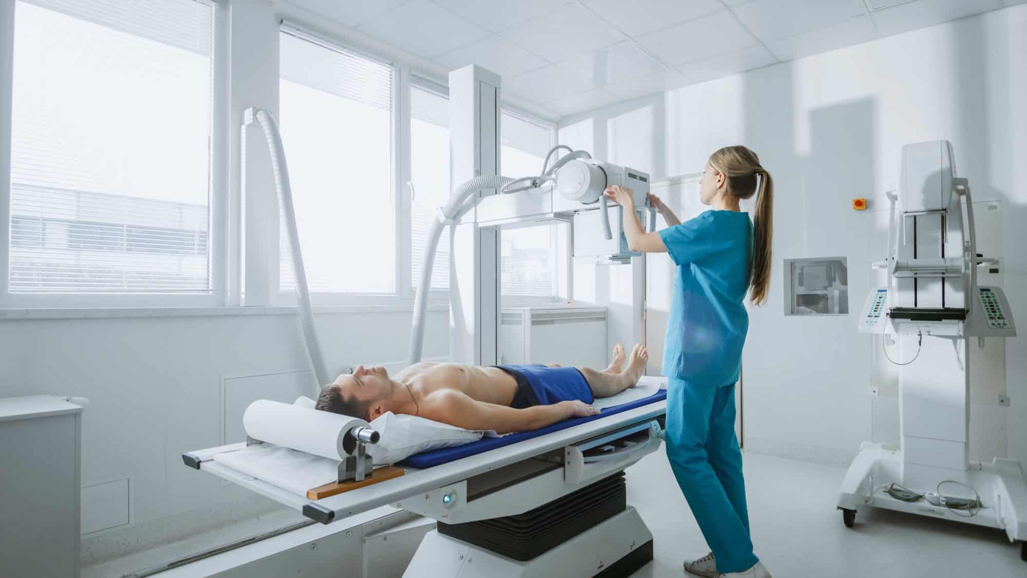 A medical radiology technician scanning a patient.